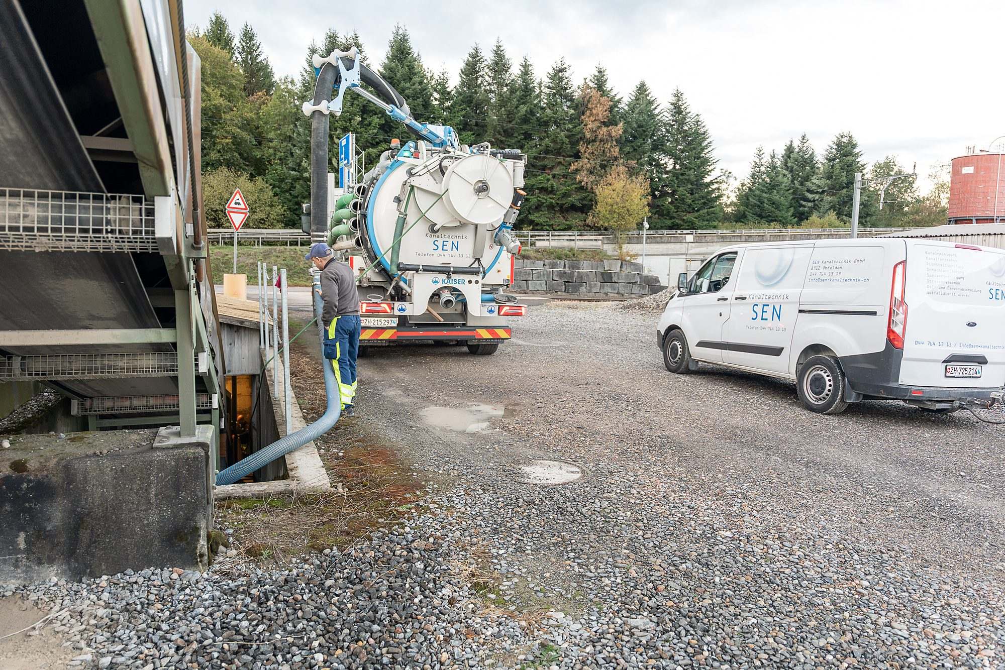 Der Saugschlauch führt vom Saugwagen in einen Schacht, ein Mitarbeiter führt ihn